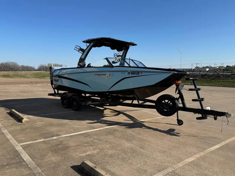 Slide: The Image of 2023 Tigé Z3 boat on trailer in parking lot under clear blue sky. - 2