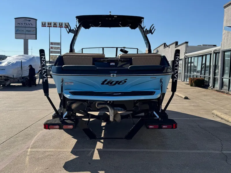 Slide: The Image of 2023 Tigé Z3 boat rear view in parking lot, showcasing sleek design and branding. - 3