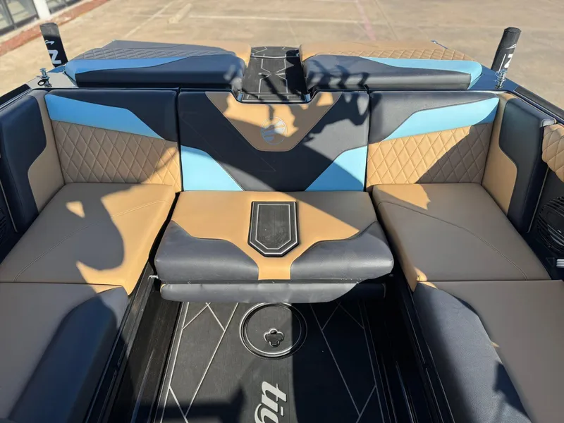 Slide: The Image of 2023 Tigé Z3 boat interior with tan and blue seating, diamond stitching, and central storage. - 8