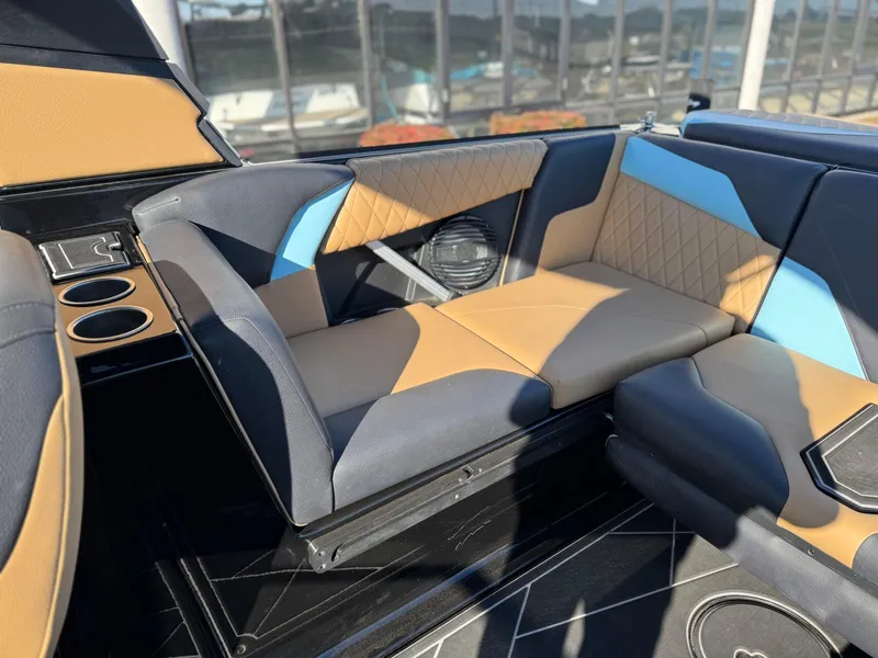 Slide: The Image of 2023 Tigé Z3 boat interior with tan and blue seating, cup holders, and speaker. - 9