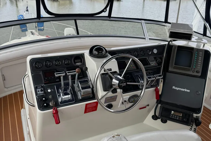 Slide: The Image of 1995 Carver 440 Aft Cabin Motor Yacht helm with steering wheel and navigation equipment. - 10