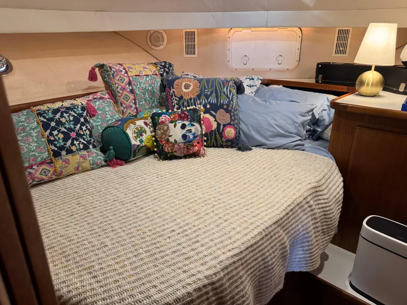 Slide: The Image of Cozy cabin interior of 1995 Carver 440 Aft Cabin Motor Yacht with colorful pillows and lamp. - 13