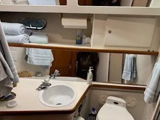 Slide: The Image of 1995 Carver 440 Aft Cabin Motor Yacht bathroom with sink, toilet, and towels. - 16