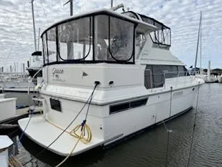 Slide: The Image of 1995 Carver 440 Aft Cabin Motor Yacht docked in marina, side view. - 2