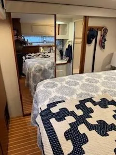 Slide: The Image of Interior of 1995 Carver 440 Aft Cabin Motor Yacht with cozy bedroom and patterned bedding. - 24