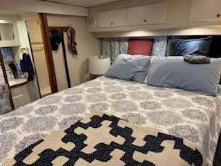 Slide: The Image of 1995 Carver 440 Aft Cabin Motor Yacht bedroom with patterned bedding and cozy decor. - 26