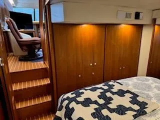 Slide: The Image of 1995 Carver 440 Aft Cabin Motor Yacht interior with wood paneling and cozy bedding. - 27