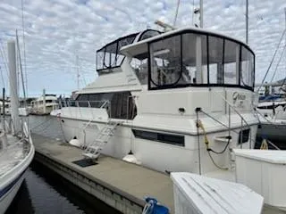 Slide: The Image of 1995 Carver 440 Aft Cabin Motor Yacht docked at marina under cloudy sky. - 3
