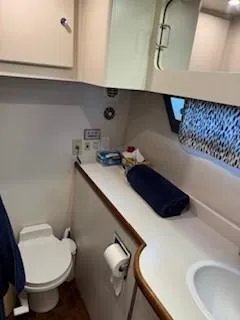 Slide: The Image of 1995 Carver 440 Aft Cabin Motor Yacht bathroom with sink, toilet, and storage. - 32
