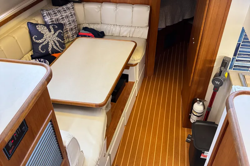 Slide: The Image of 1995 Carver 440 Aft Cabin Motor Yacht interior with dining area and wooden flooring. - 34