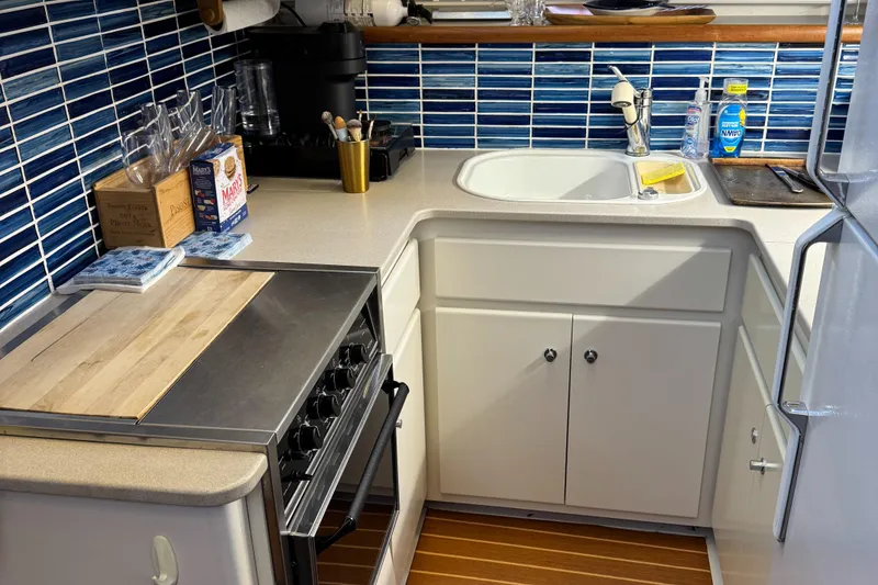 Slide: The Image of 1995 Carver 440 Aft Cabin Motor Yacht kitchen with blue tile backsplash and modern appliances. - 35