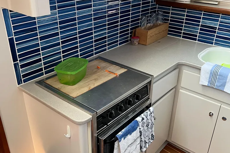 Slide: The Image of Compact kitchen in a 1995 Carver 440 Aft Cabin Motor Yacht with blue tile backsplash. - 36