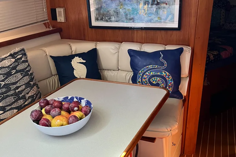 Slide: The Image of 1995 Carver 440 Aft Cabin Motor Yacht interior with cushioned seating and decorative pillows. - 37