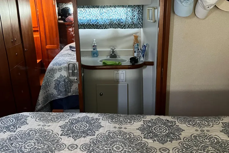 Slide: The Image of 1995 Carver 440 Aft Cabin Motor Yacht interior with patterned bedding and compact bathroom. - 40