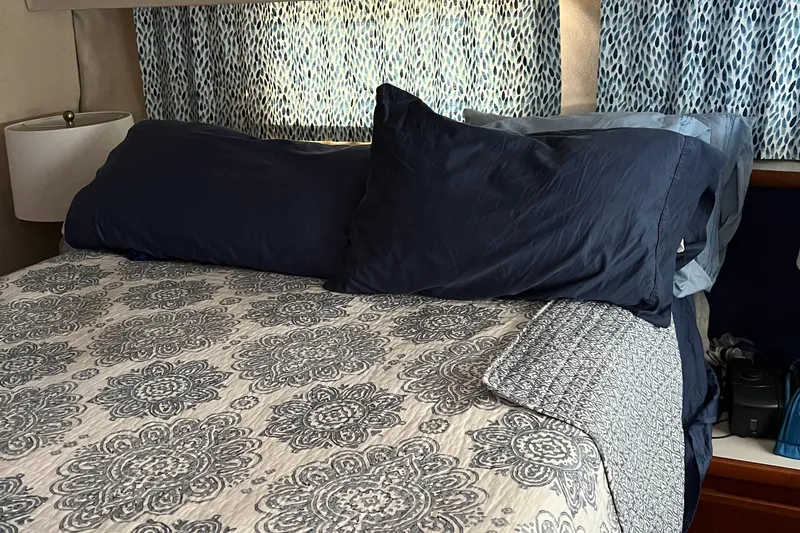 Slide: The Image of Cozy bedroom in 1995 Carver 440 Aft Cabin Motor Yacht with patterned bedding and blue pillows. - 41