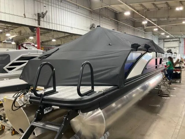 Slide: The Image of 2025 Bennington M Swingback 22 MSB pontoon boat covered in a warehouse setting. - 4