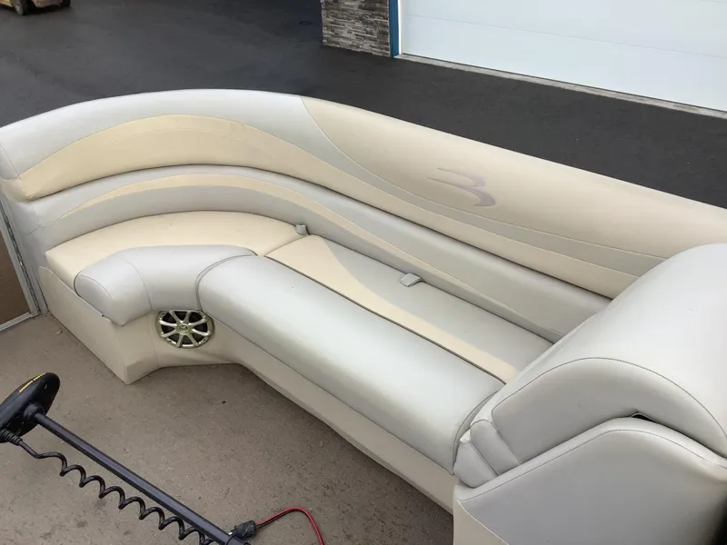 Slide: The Image of 2013 Bennington 2275 boat interior with beige seating and speaker detail. - 11
