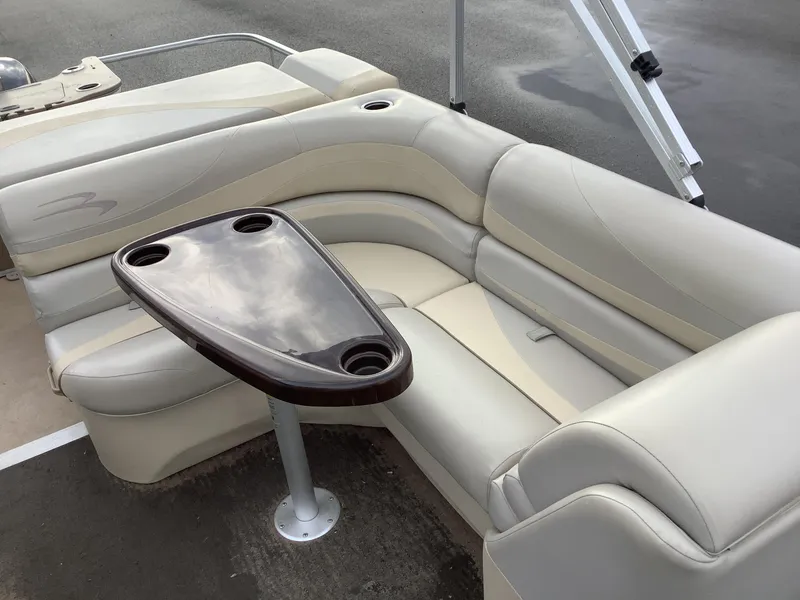 Slide: The Image of 2013 Bennington 2275 boat interior with beige seating and a central table. - 13