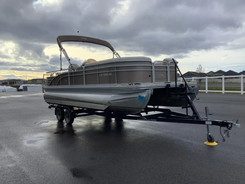 Slide: The Image of 2013 Bennington 2275 pontoon boat on trailer under cloudy sky. - 4