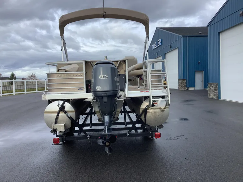 Slide: The Image of 2013 Bennington 2275 pontoon boat with Yamaha 115 engine, parked near blue building. - 7