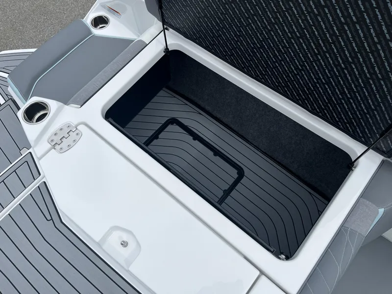 Slide: The Image of 2024 Nautique Super Air G25 storage compartment with sleek design and cup holders. - 10