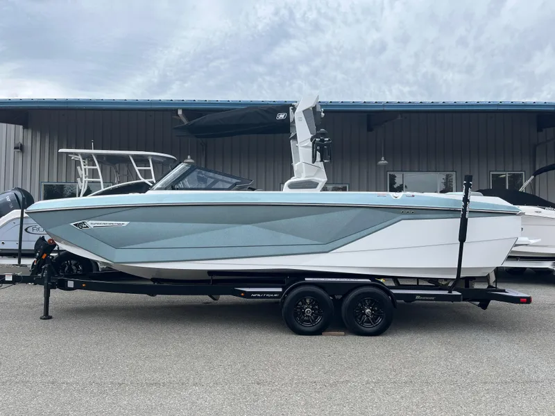Slide: The Image of 2024 Nautique Super Air G25 boat on trailer, side view, outdoors. - 17