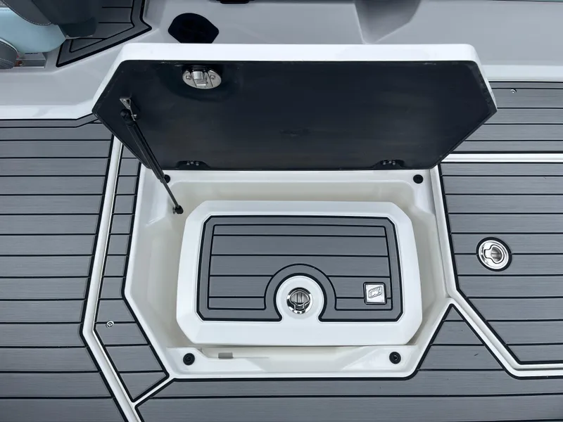 Slide: The Image of 2024 Nautique Super Air G25 storage compartment with open lid on sleek deck. - 18