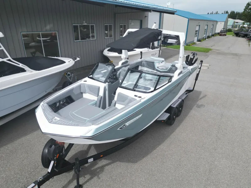 Slide: The Image of 2024 Nautique Super Air G25 boat on trailer, parked outside a building. - 3