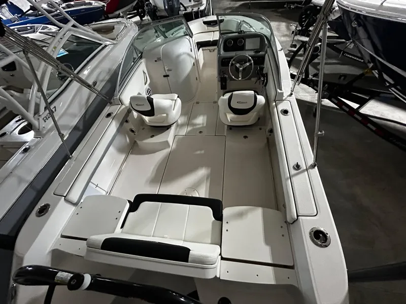 Slide: The Image of 2023 Robalo 207 boat interior with seating and steering wheel in a showroom. - 4