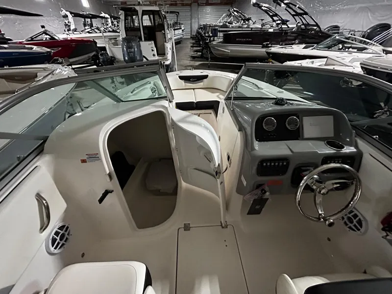 Slide: The Image of 2023 Robalo 207 boat interior with steering console and cabin, displayed in a showroom. - 8