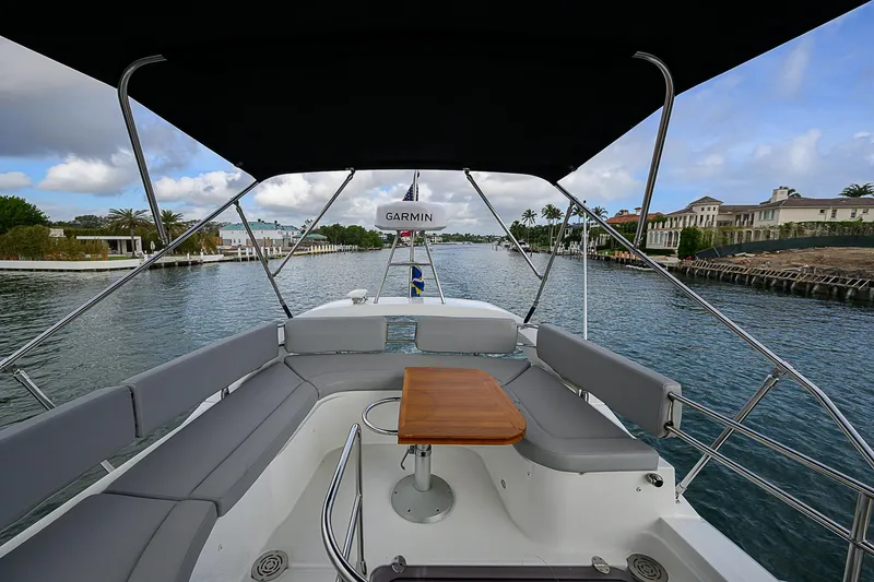 Slide: The Image of 2017 Beneteau Gran Turismo 49 yacht interior with seating and table, under canopy, on waterway. - 12