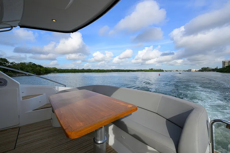 Slide: The Image of 2017 Beneteau Gran Turismo 49 yacht with outdoor seating, cruising on a scenic waterway. - 46