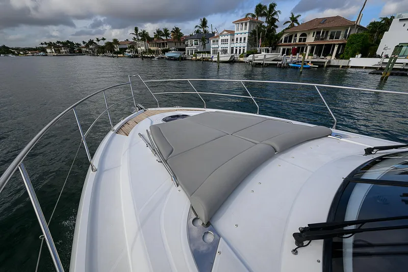 Slide: The Image of 2017 Beneteau Gran Turismo 49 yacht with sunpad, cruising near waterfront homes. - 6