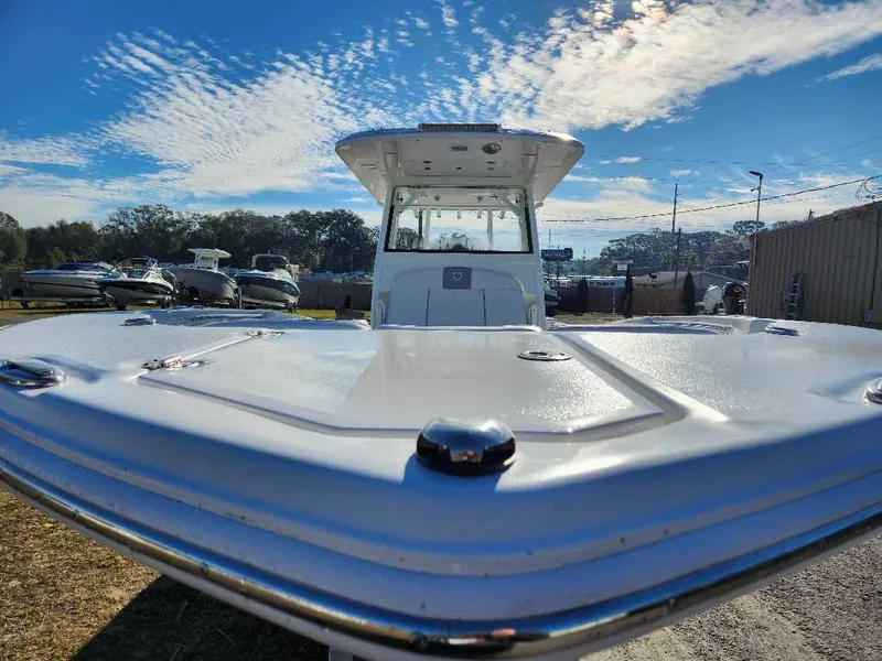 Slide: The Image of 2025 Sea Fox 288 Commander boat under a clear blue sky at a marina. - 2