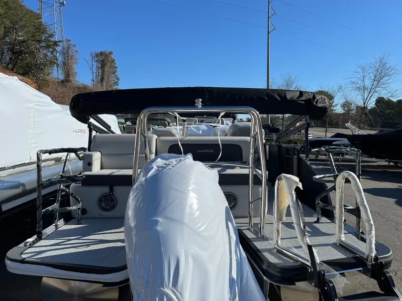 Slide: The Image of 2025 Harris Cruiser 230 pontoon boat with black canopy in storage yard. - 4