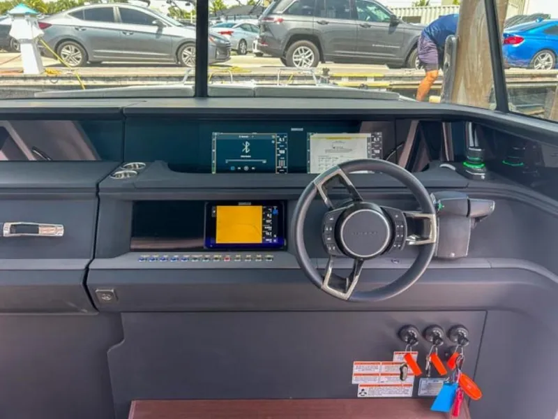 Slide: The Image of 2024 Axopar 45 XC Cross Cabin dashboard with steering wheel and navigation screens. - 12