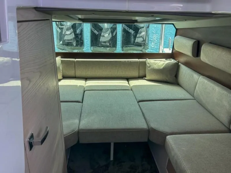 Slide: The Image of 2024 Axopar 45 XC Cross Cabin interior with cozy seating and window view. - 23