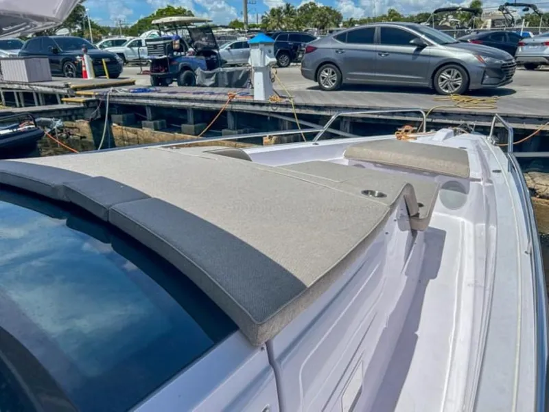 Slide: The Image of 2024 Axopar 45 XC Cross Cabin boat docked, featuring cushioned deck seating. - 8