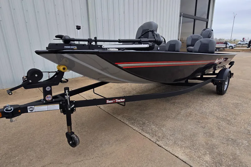 Slide: The Image of 2025 Tracker Bass Tracker Classic XL boat on trailer, parked outside a building. - 2