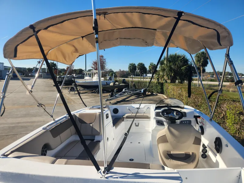 Slide: The Image of 2025 Tahoe 1950 boat with canopy, beige interior, parked outdoors. - 3
