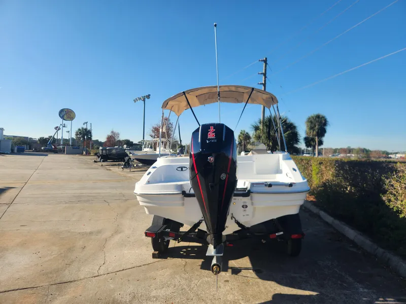 Slide: The Image of 2025 Tahoe 1950 boat with canopy and outboard motor in a sunny parking lot. - 5