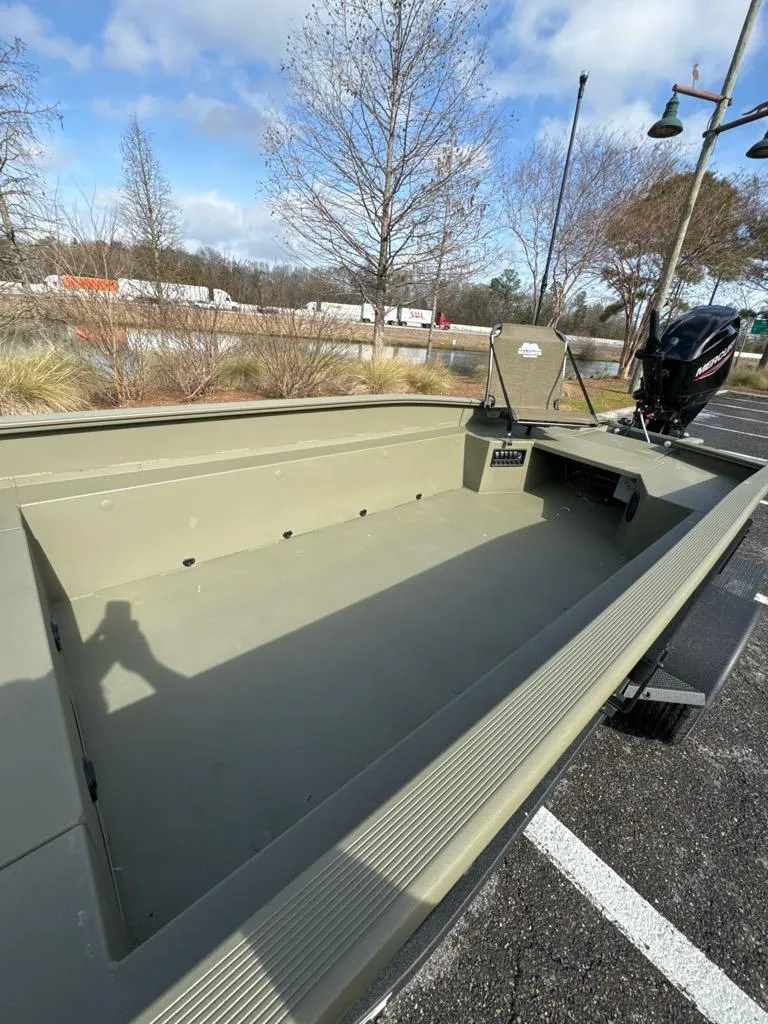 Slide: The Image of 2025 Tracker Grizzly 1650 T Prairie Wings Edition boat, spacious interior, parked outdoors. - 5