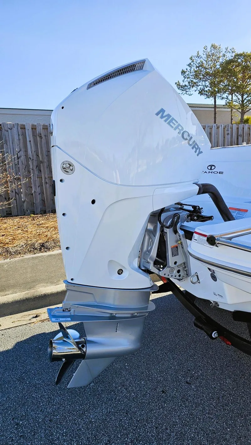 Slide: The Image of 2025 Tahoe 2150 CC boat with Mercury outboard motor, parked outdoors. - 3