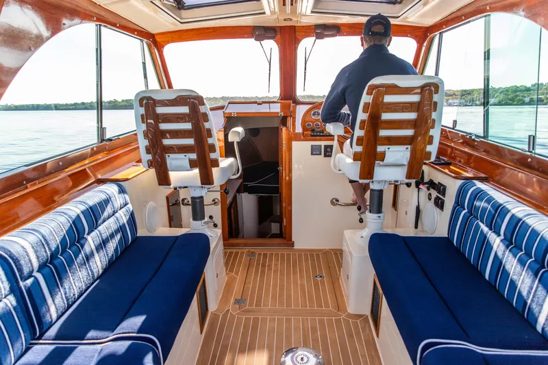 Slide: The Image of Interior of 2022 Hinckley Picnic Boat 34 S with polished wood and control panel. - 12