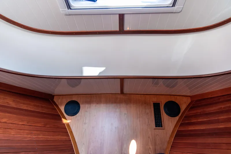 Slide: The Image of 2022 Hinckley Picnic Boat 34 S interior kitchen with wood cabinetry, microwave, and sink. - 20