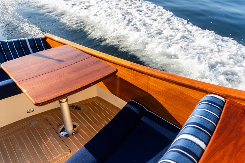 Slide: The Image of 2022 Hinckley Picnic Boat 34 S cruising on calm water, showcasing sleek design. - 7