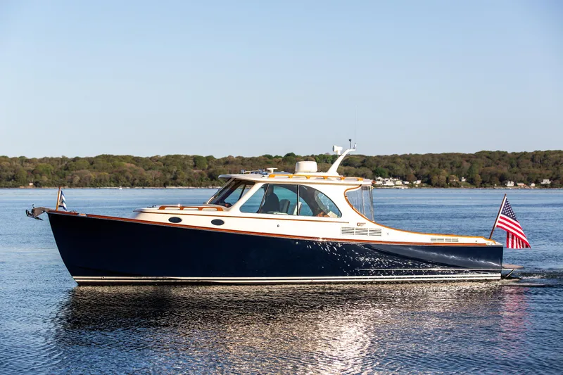 Slide: The Image of Hinckley Picnic Boat 34 S 2022 dashboard with navigation screen and wooden steering wheel. - 1