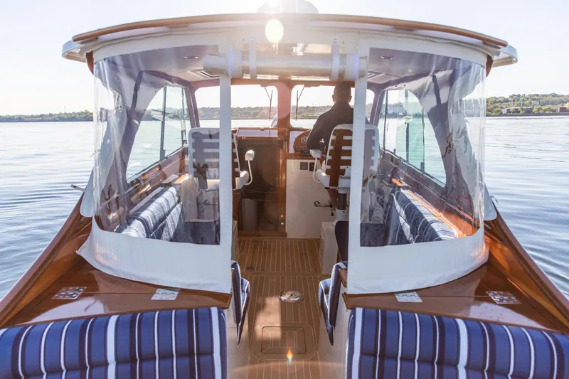 Slide: The Image of Steering wheel of 2022 Hinckley Picnic Boat 34 S, featuring polished wood and metal design. - 11