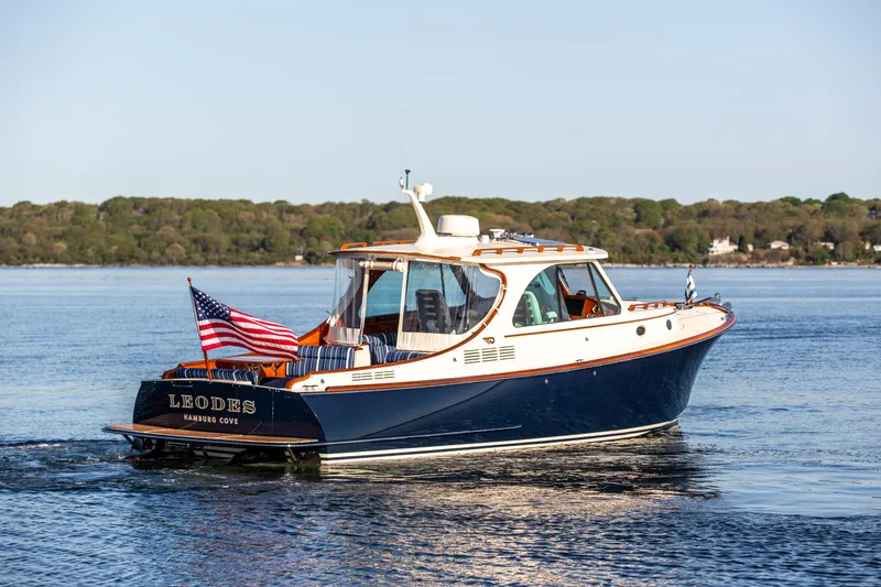 Slide: The Image of 2022 Hinckley Picnic Boat 34 S interior with blue seating and wooden accents. - 2