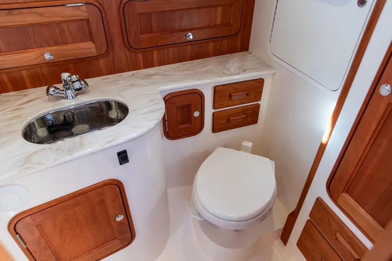 Slide: The Image of Hinckley Picnic Boat 34 S 2022 interior with wooden cabinetry and sink. - 23